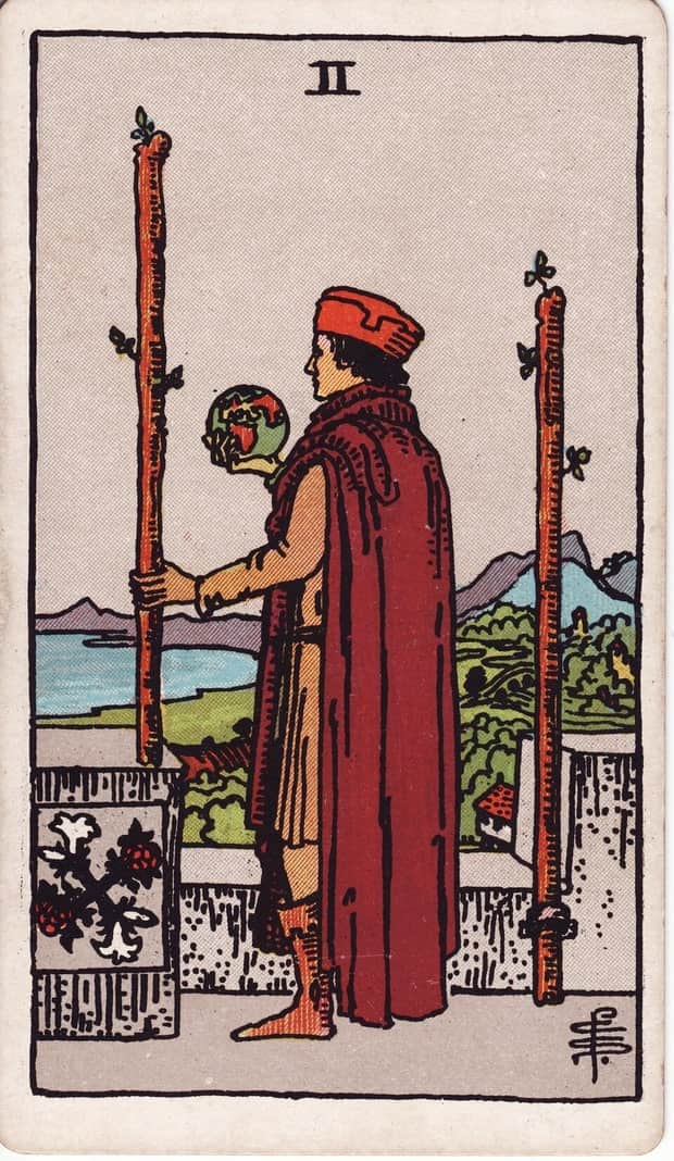 A gravura da carta Dois de Paus no baralho de tarot Rider-Waite-Smith
